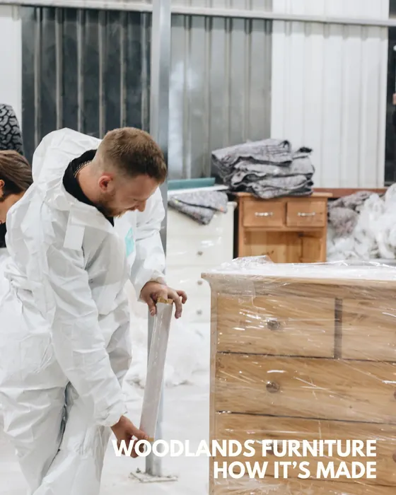 Woodlands Furniture craftsperson hand-finishing a chest of drawers in the English factory