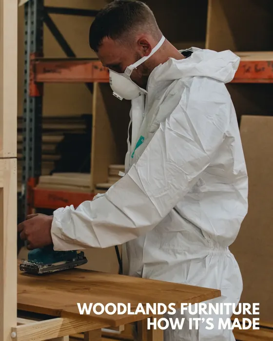 Woodlands Furniture craftsperson sanding solid wood by hand